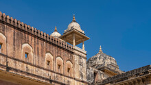 The Weathered Wall Of The Ancient Amber Fort Against A Clear Blue Sky. Loopholes, Watchtowers With Domes And Spires Are Visible. India. Jaipur.