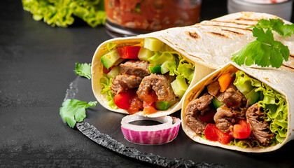 burritos wraps with beef and vegetables on black background. beef burrito, mexican food.