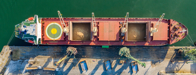 Panoramic view from a drone of a large ship loading grain for export. Water transport