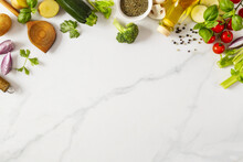 Food Cooking Ingredients Background With Fresh Vegetables, Herbs, Spices And Olive Oil On Marble Table With Copy Space Top View. Healthy Vegetarian Eating