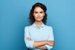 © olegganko - Woman posing with arms crossed on blue background