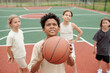 © pressmaster - Cute schoolboy with ball looking upwards before throwing it into basket while standing in front of camera against group of classmates