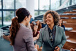 © Drazen - Happy businesswoman handshaking with public speaker during seminar in convention center.