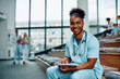 © Drazen - Happy black medical student learning in amphitheater at university and looking at camera.