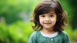 © HN Works - Smiling little girl posing against green background with space for text