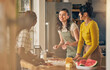 © Davids C/peopleimages.com - Happy, friends and women cooking pizza in kitchen, bonding and having fun together in home. Smile, girls and baking food, margherita and salami bread at lunch, cheese on meat and watermelon at brunch