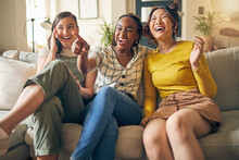 Happy, Friends And Women Watching Tv On A Sofa Laughing, Bond And Relax In Their Home On The Weekend. Television, Movie And People With Diversity In Living Room For Streaming, Film Or Comedy In House