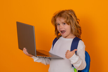 Aufkleber - Smart child, clever school kid. School child with thumb up using laptop computer. Portrait of school boy isolated on yellow studio background. Back to school.