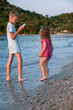 © Vladyslav - Brother and sister are playing on the beach. A girl and a boy are playing with homemade boats in sea water. Children splash in the Adriatic Sea.