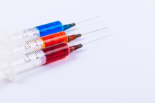 Medical Syringes With Needles Isolated On White. Macro Shooting. Syringes Filled With Colored Medication Liquids.