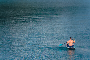 Wall Mural - man on paddleboard in the middle of the lake