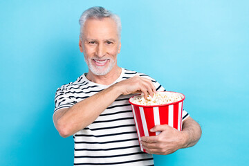 Canvas Print - Photo of optimistic glad stylish man wear eating delicious popcorn watching interesting movie isolated on blue color background