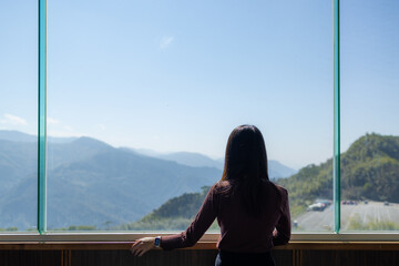 Poster - Woman look at the mountain scenery inside the building