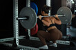 Back view, woman lifting weight, squatting with barbell in gym, sporty woman exercising 