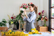 © Katcha - Female florist in apron holding white chrysanthemum with enjoying to creating and designing floral for