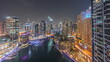 Aerial view to Dubai marina skyscrapers around canal with floating boats day to night timelapse