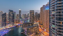 Aerial View To Dubai Marina Skyscrapers Around Canal With Floating Boats Day To Night Timelapse