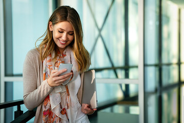 Wall Mural - Beautiful business woman using mobile phone outdoors. People communication technology concept.