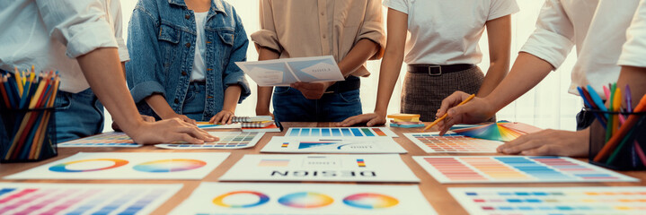 Poster - Graphic designer brainstorm logo and graphic art at busy creative studio workshop. Experiment and brainstorm color palette and pattern at workspace table for creative design. Panorama shot. Scrutinize