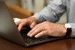© New Africa - Man working on laptop at table in cafe, closeup