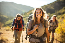 Smiling Woman Hiker With Backpack Looking At Camera With Group Of Friends Hikers Rises To The Top Of The Hill