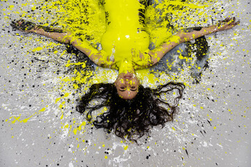 Wall Mural - sexy naked woman in yellow, green, black, white color painted, lies decorative, elegant on the Studio floor. Creative, abstract expressive body art painting