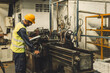 © Quality Stock Arts - Hispanic Latin Indian male professional tecnician worker working with steel precision milling machine in lathe metal factory