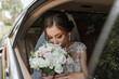 © Vasil - close-up portrait of a rather shy bride in a car window looking at her bouquet of flowers