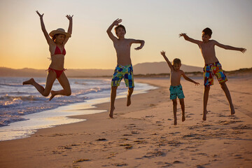 Poster - Happy children, boys, playing on the beach on sunset, kid cover in sand, smiling, laughing