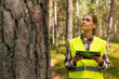 © ronstik - forest evaluation, development and management - female forestry engineer or appraiser working with digital tablet in the woods