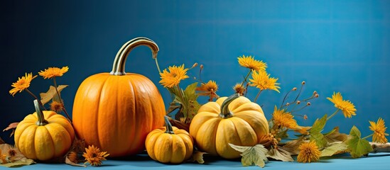 Wall Mural - Beautiful pumpkins with yellow leaves on blue background are in the corners