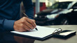 person signing a contract document for car dealership repair shop