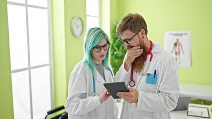 Wall Mural - Man and woman doctors using touchpad working at clinic