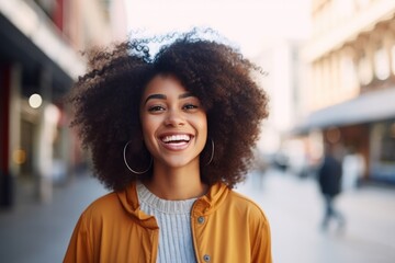 Wall Mural - young happy african american woman smiling on blurry city background