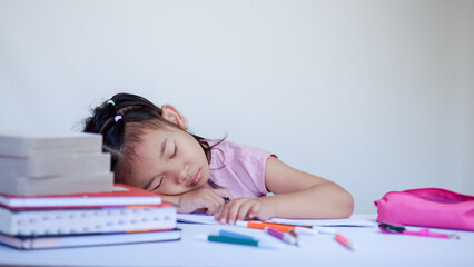 Wall Mural - Portrait Of Cute Little Asian Female Child Sleeping At Desk Tired After Doing School Homework, Exhausted Girl Using Of Books As Pillow, Napping At Table At Home, Closeup Shot, Free Space.