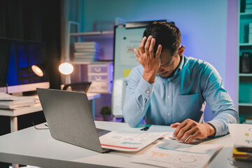 Male employee working late and stressed with failed work Young asian businessman working hard on laptop computer at office overtime at night overtime concept