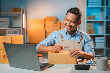 Young male entrepreneur selling products online Prepare packing boxes to send to customers. Concept of business man doing e-commerce business on website and social media Sell ​​products online.