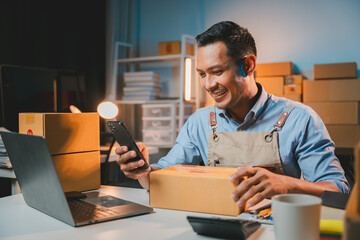 Young male entrepreneur selling products online Prepare packing boxes to send to customers. Concept of business man doing e-commerce business on website and social media Sell ​​products online.