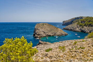 Wall Mural - view of a small bay on the costa brava where motorboats are anchored under a sunny blue sky