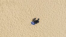 Top View Of Man With Metal Detector Looking For Precious Objects On The Beach Of Santa Monica, Los Angeles, California, USA. Person Using Technology To Find Treasures In The Sand, 4k Footage