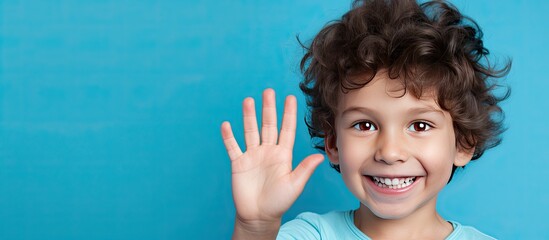 Poster - Portrait of a five year old boy displaying five fingers on a blue background with empty space