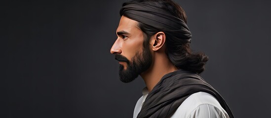 Profile portrait of a young man in traditional Pakistani attire with dark hair mustache and beard against a gray background Horizontal banner with empt