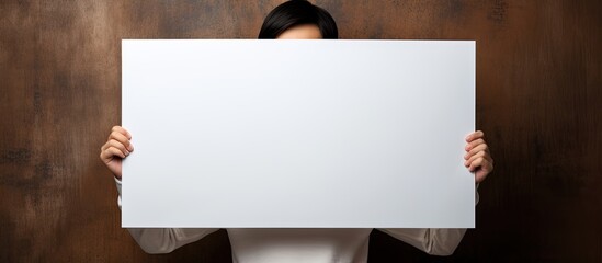 Aufkleber - Blank white banner held by young girl on brown background Copy space