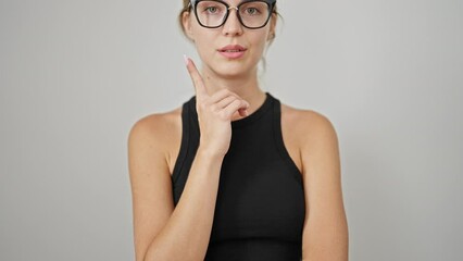 Wall Mural - Young blonde woman standing with doubt expression over isolated white background