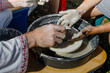 master class on modeling clay, creating a vase, bowl, pot on potter's wheels in the workshop. the master helps the child