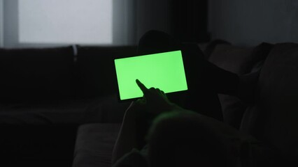 Wall Mural - Man at home lying on a couch with tablet pc with green screen