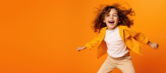 Cute Young Happy Girl iDancing on a Orange Background with Space for Copy