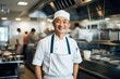 © Baba Images - Middle aged japanese chef working and preparing food in a restaurant kitchen smiling portrait
