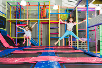 Happy children laughing while playing and jumping on the trampoline