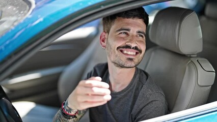 Wall Mural - Young hispanic man smiling confident receiving key of new car at street